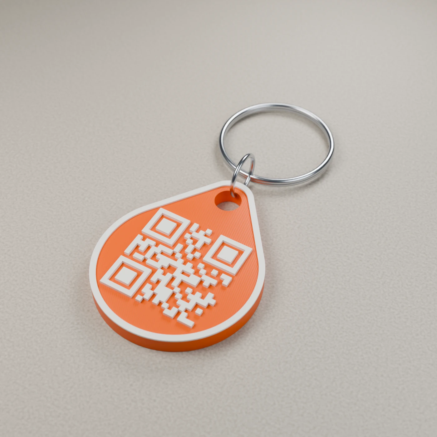 Orange Linkz QR tag with a silver keyring on a warm stone surface